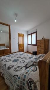 a bedroom with a large bed and a dresser at Apartamento Mari Carmen in Muxia