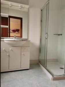 a bathroom with a sink and a shower with a mirror at Apartamento Mari Carmen in Muxia