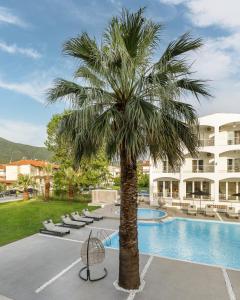 una palmera frente a un edificio con piscina en Stavros Beach Hotel en Stavros