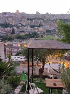 a garden with a pergola and a view of a city at Casa Sabir in Modica