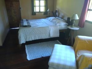 1 dormitorio con cama, mesa y ventana en Fazenda pedra selada, en Visconde De Maua