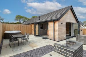 un patio con mesa y sillas y un edificio en Cedar Cottage, en Tenby