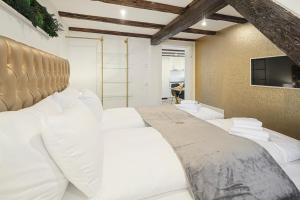 1 dormitorio con 1 cama grande con almohadas blancas en EH Apartments Saturn, en St. Gallen