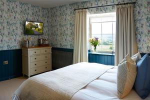 1 dormitorio con cama, ventana y vestidor en The Grainary Boutique Hotel en Scarborough