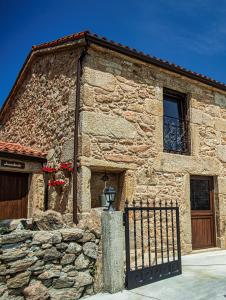 a stone building with a gate and a window at A casiña do Pozo in Crucero