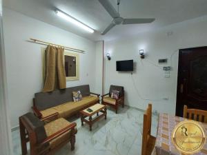 un soggiorno con divano, sedie e TV di Royal Apartments in Matrouh a Marsa Matruh