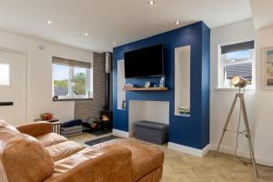 ein Wohnzimmer mit einem Sofa und einer blauen Wand in der Unterkunft Hazel Cottage in Tenby