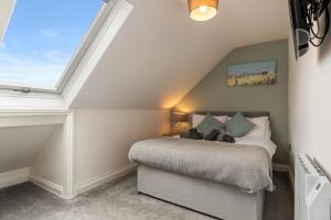 a bedroom with a bed and a window at Hazel Cottage in Tenby +28 photos