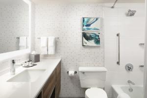 a white bathroom with a toilet and a sink at Crowne Plaza Houston Med Ctr-Galleria Area, an IHG Hotel in Houston