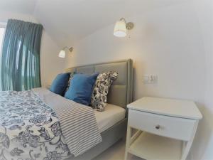 a bed with blue pillows and a night stand in a bedroom at La Palma in Władysławowo