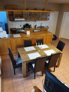 a kitchen with a wooden table with chairs and a kitchen at Andris Apartman- Fonyód Tabán u 78 in Fonyód