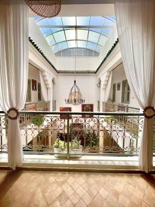 een grote kamer met een balkon met witte gordijnen bij Riad Dar Chadia in Marrakesh