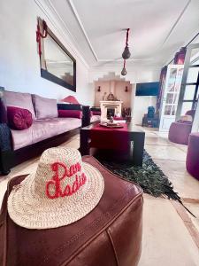 - un salon avec un chapeau assis sur un canapé dans l'établissement Riad Dar Chadia, à Marrakech
