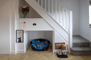 a room with a dog crate under the stairs at Hazel Cottage in Tenby