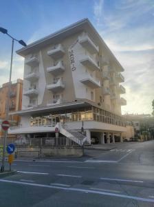 a large white building with balconies on a street at Hotel Madrid in Rimini