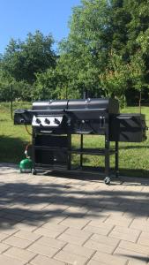 a black barbecue grill sitting on a sidewalk in a park at Brunetti Villa Zlín in Zlín