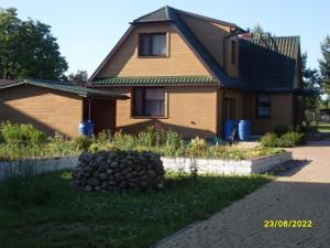 a house with a pile of rocks in front of it at U Heleny i Piotra pokoje goscinne in Białowieża +8 photos