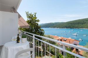 a balcony with a table and a view of the water at Jadranka in Rabac +5 photos