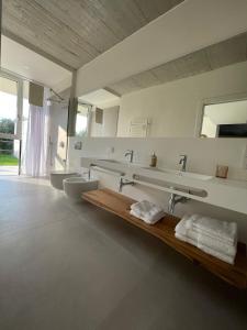 a large bathroom with three sinks and two mirrors at Guendalina Suite 2 in Verona