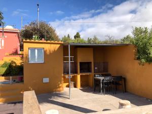 a small house with a patio and a table at Casa Cesar in Puntagorda