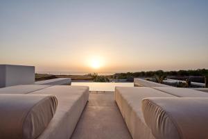 une rangée de lits sur un toit avec vue sur le coucher du soleil dans l'établissement Lilium Homes, à Karterados