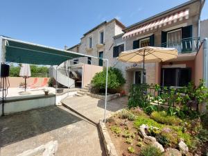patio con ombrellone di fronte a casa di Holiday Home Oliva a Bilice (Bilizze)