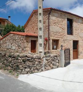 a stone building with a ladder on the side of it at A casiña do Pozo in Crucero