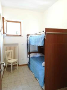 una camera da letto con un letto a castello e una sedia di Giardino sul Mare - Casa Casoni a Numana