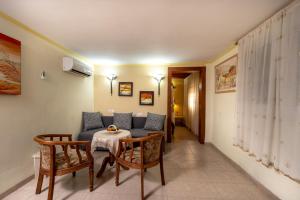 a living room with a couch and a table and chairs at Carcom Lake View in Karkom