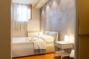 a small bedroom with a bed and a window at Mr Brown Suites - EUR in Rome