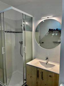 a bathroom with a sink and a shower with a mirror at Superbe studio lumineux haut de gamme tout confort in Drancy