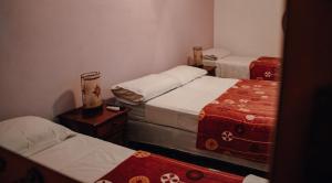 un grupo de 3 camas en una habitación en Cabañas y Hostal Las Marias en Cafayate