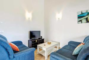 カラン・ボッシュにあるEs Romaniのリビングルーム(青い椅子2脚、テレビ付)