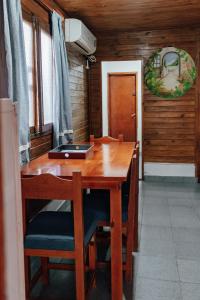 una mesa de madera con sillas y un ordenador portátil. en Cabañas y Hostal Las Marias en Cafayate
