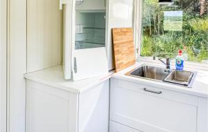 eine weiße Küche mit einem Waschbecken und einem Fenster in der Unterkunft 1 Bedroom Nice Home In Varberg in Varberg