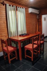 a wooden table with two chairs and a desk with a window at Cabañas y Hostal Las Marias in Cafayate