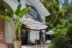 a patio with chairs and umbrellas in front of a building at Casa Polanco Hotel Boutique in Mexico City