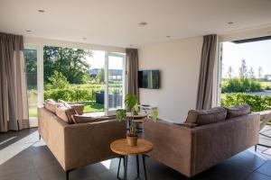 a living room with two couches and a table at Ruyge Weyde Logies - The Farmers Daughter in Oudewater