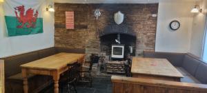 a restaurant with two wooden tables and a brick wall at Dinas Castle Inn (The Dragons Back) in Brecon