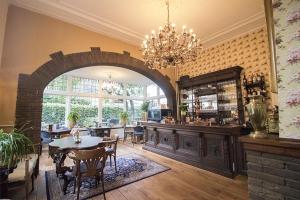 a dining room with an archway and a table and chairs at Hotellerie Het Wapen Van Athlone in De Steeg