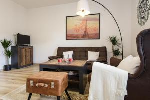 Apartment Hotel STUD MB في أوسترافا: غرفة معيشة مع أريكة وطاولة