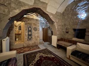 a room with a stone building with a fireplace at Anatolia Raymonde Cave House in Uçhisar
