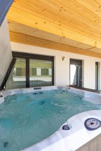 a hot tub in a room with a wooden ceiling at Aszúvilág Rezidencia with Sauna & Jacuzzi in Legyesbénye
