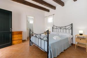 ein Schlafzimmer mit einem Bett, einer Kommode und einer Tür in der Unterkunft Holiday Home - Son Vida in Maó