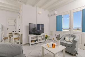 uma sala de estar com uma televisão e uma mesa em Naxos Affinity Villas em Maragkas