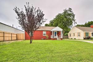 a red house with a tree in a yard at Adorable Tulsa Home Less Than 2 Mi to Expo Center! in Tulsa