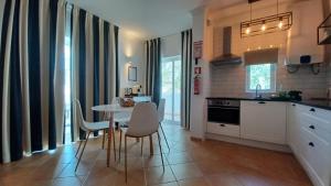 a kitchen with a table and chairs in a room at Quinta Velha 22 in Tavira