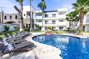 a swimming pool with chaise lounge chairs in front of a building at Casa Francisco in Cuernavaca