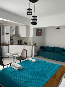 a living room with a blue bed and a kitchen at Solid Luxury Studio in Mamaia