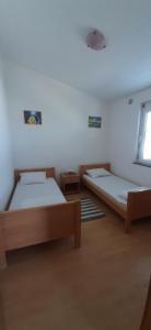 um quarto com 2 camas e uma janela em Villa Dobra Family Apartments em Vir